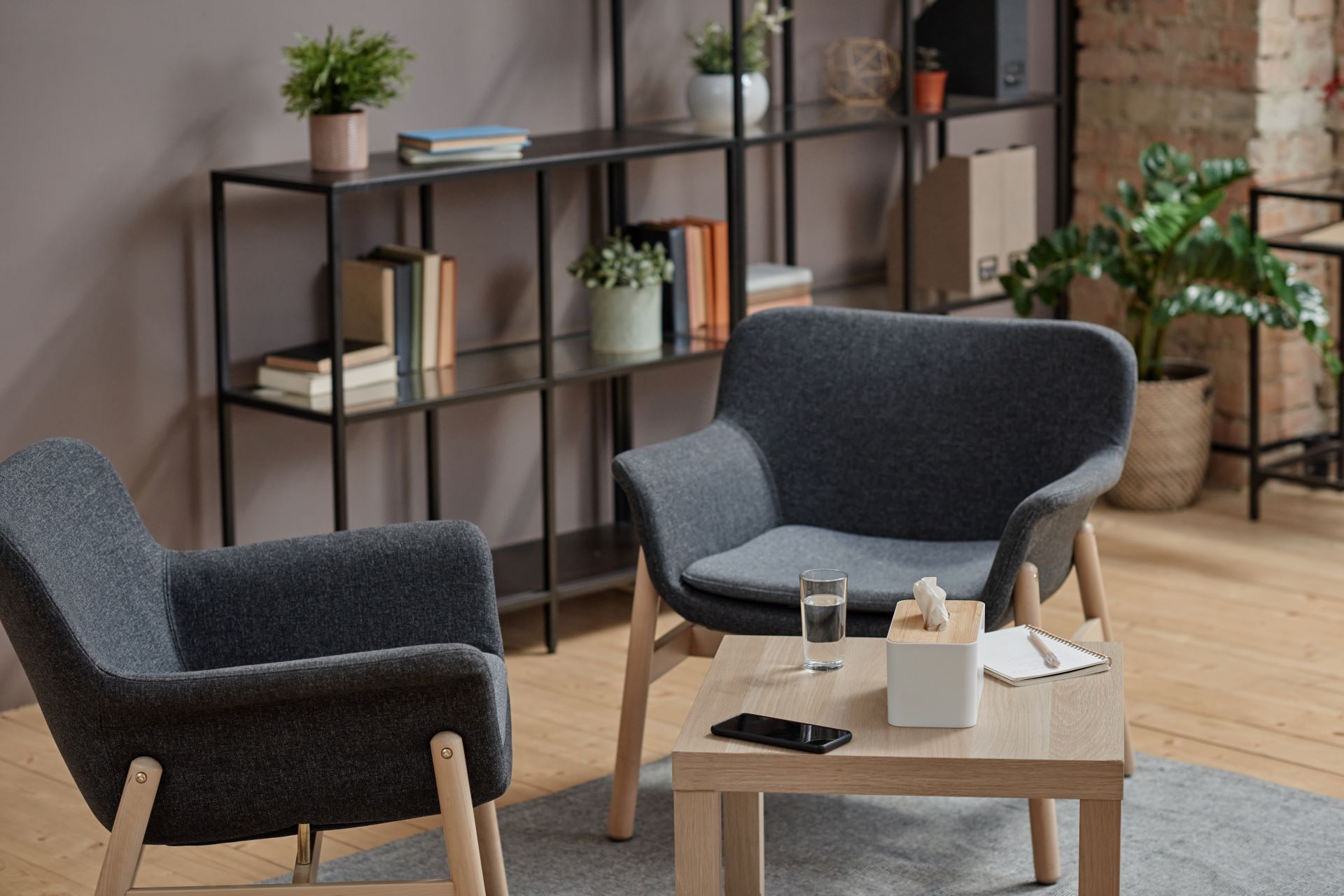 Two armchairs and a low table in a calm, private therapy office.